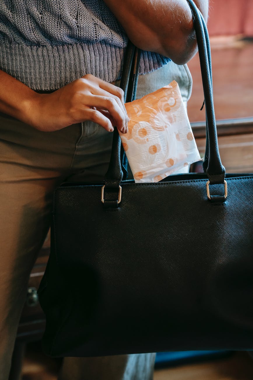 unrecognizable woman putting sanitary towel in bag
